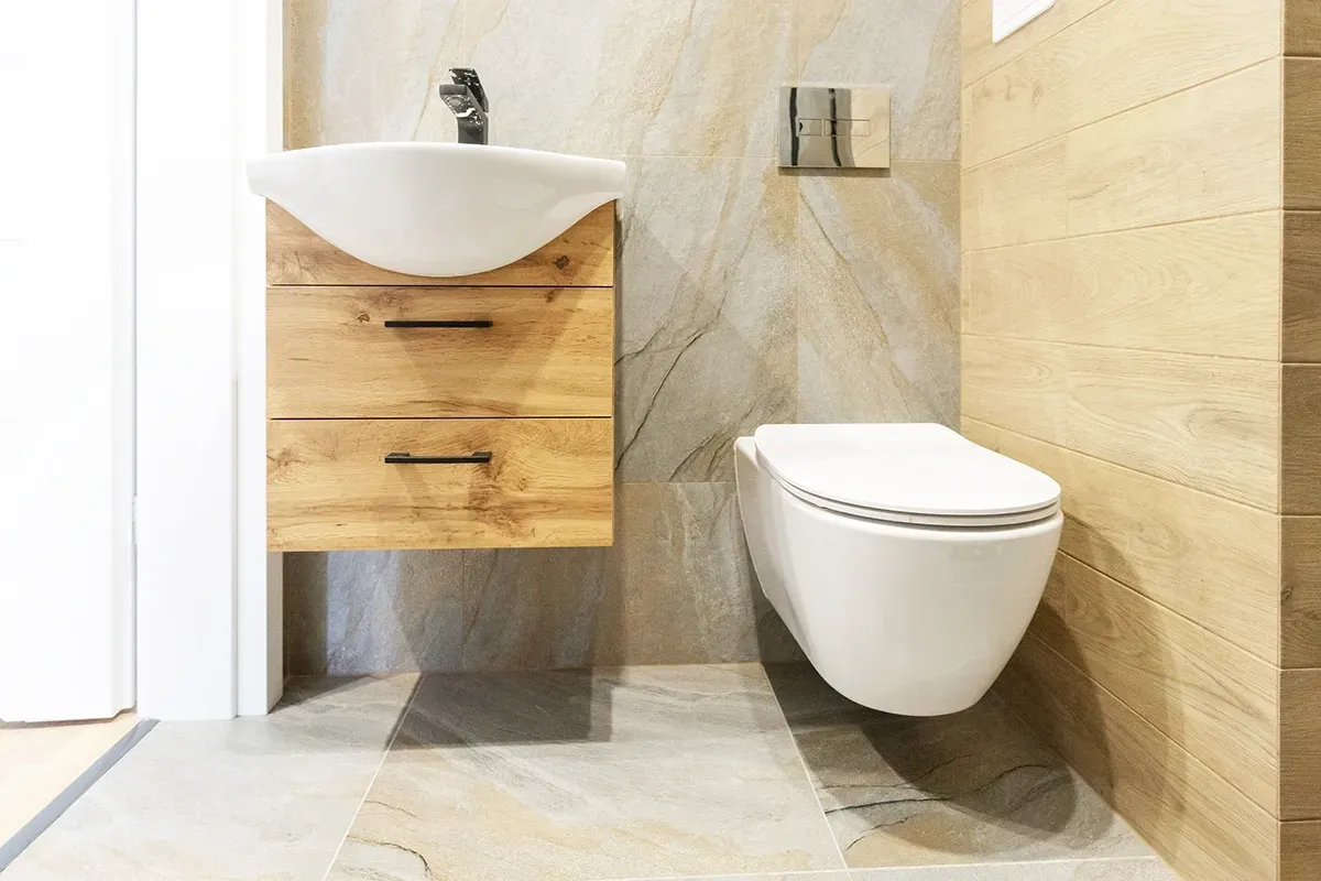Stone-look LVT flooring in a small bathroom with wood accents.