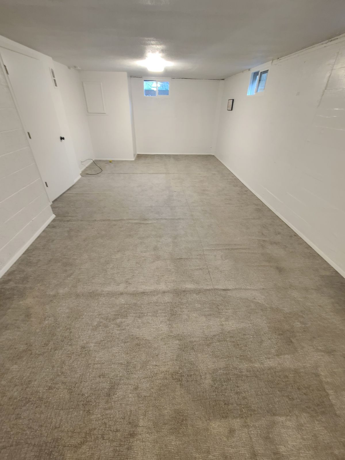 Old carpet in a large open basement.