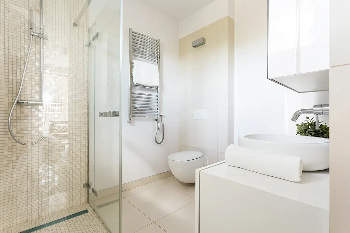 Cream-colored porcelain tile in a small bathroom with an open-format shower.