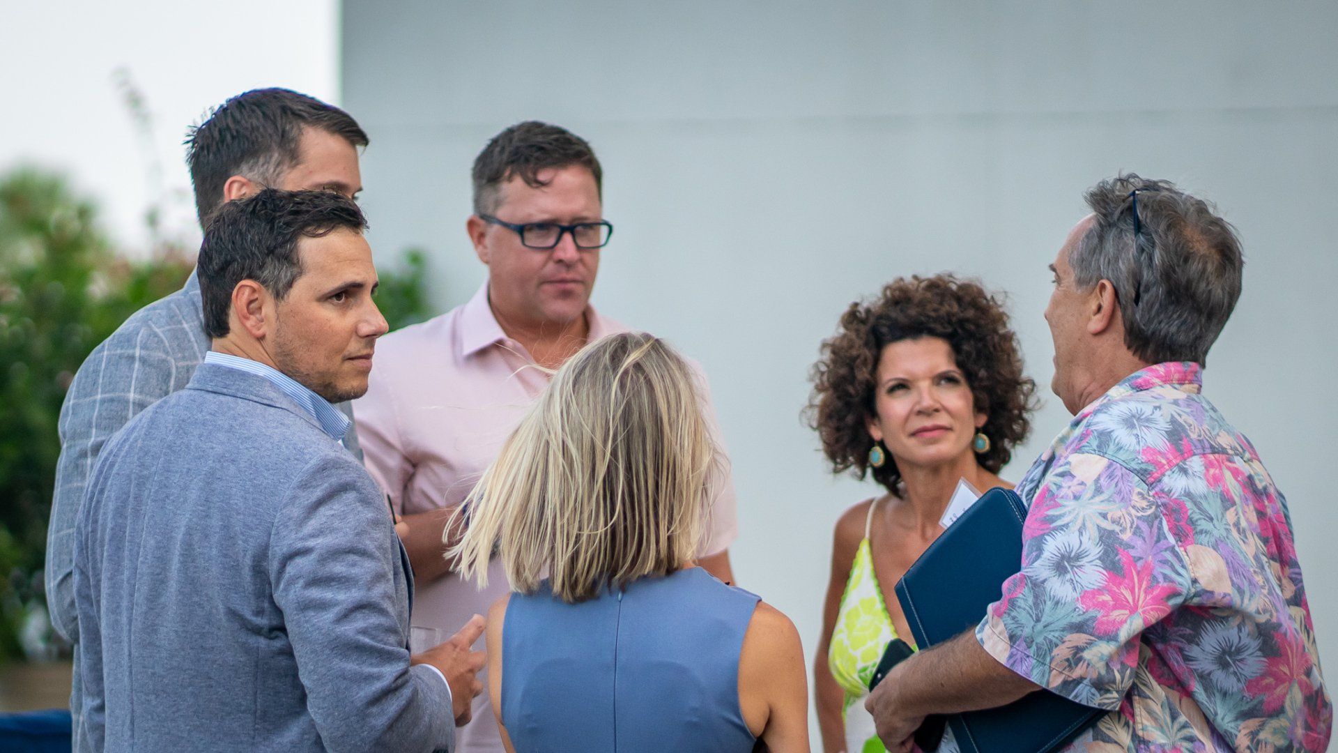 A group of people are standing in a circle talking to each other.