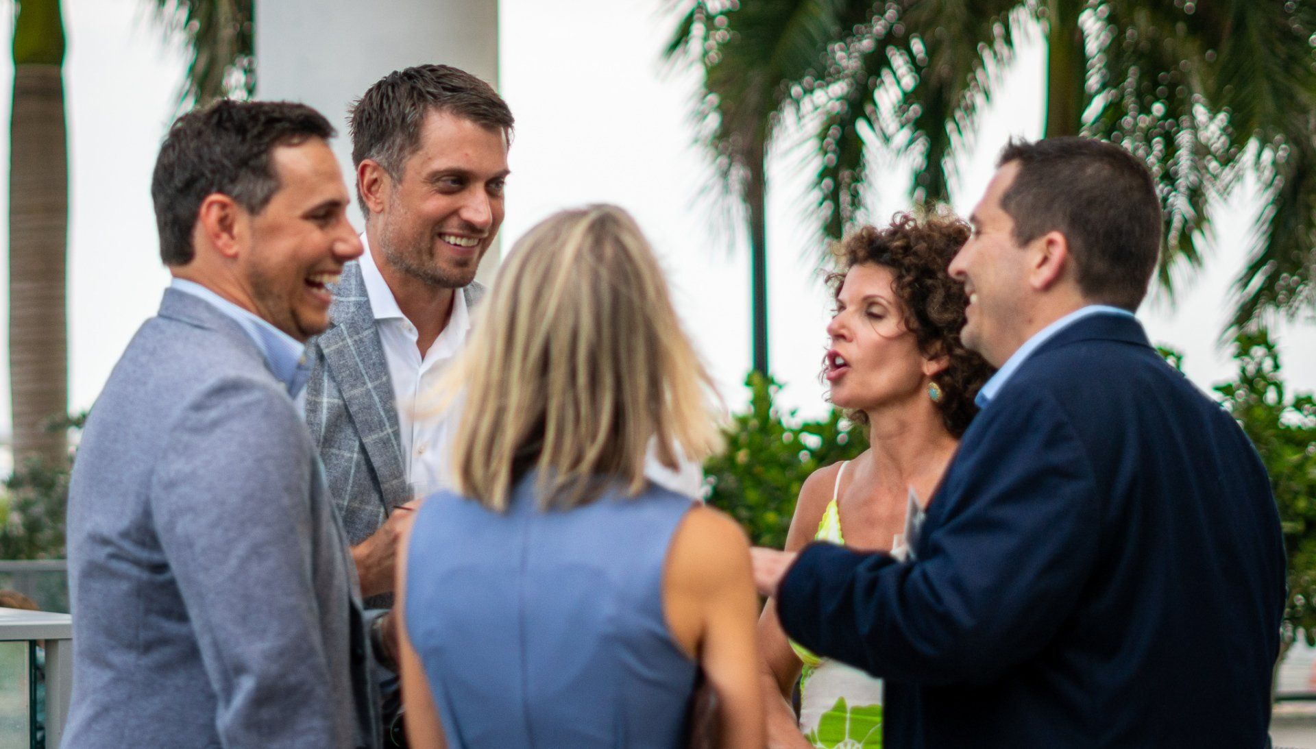 A group of people are standing around talking to each other.