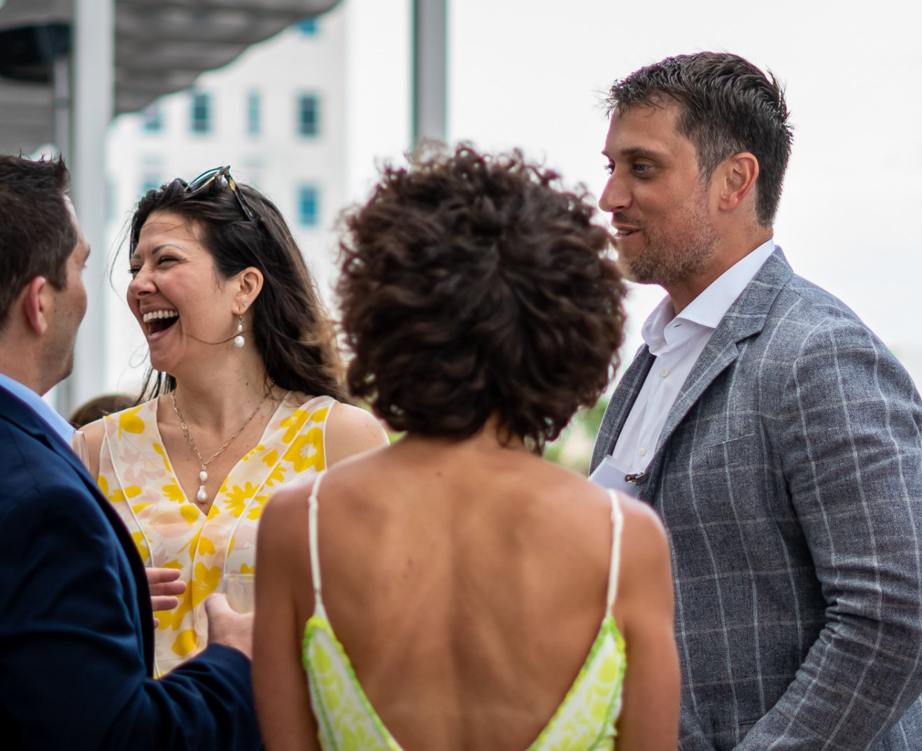 A group of people are standing around talking to each other.