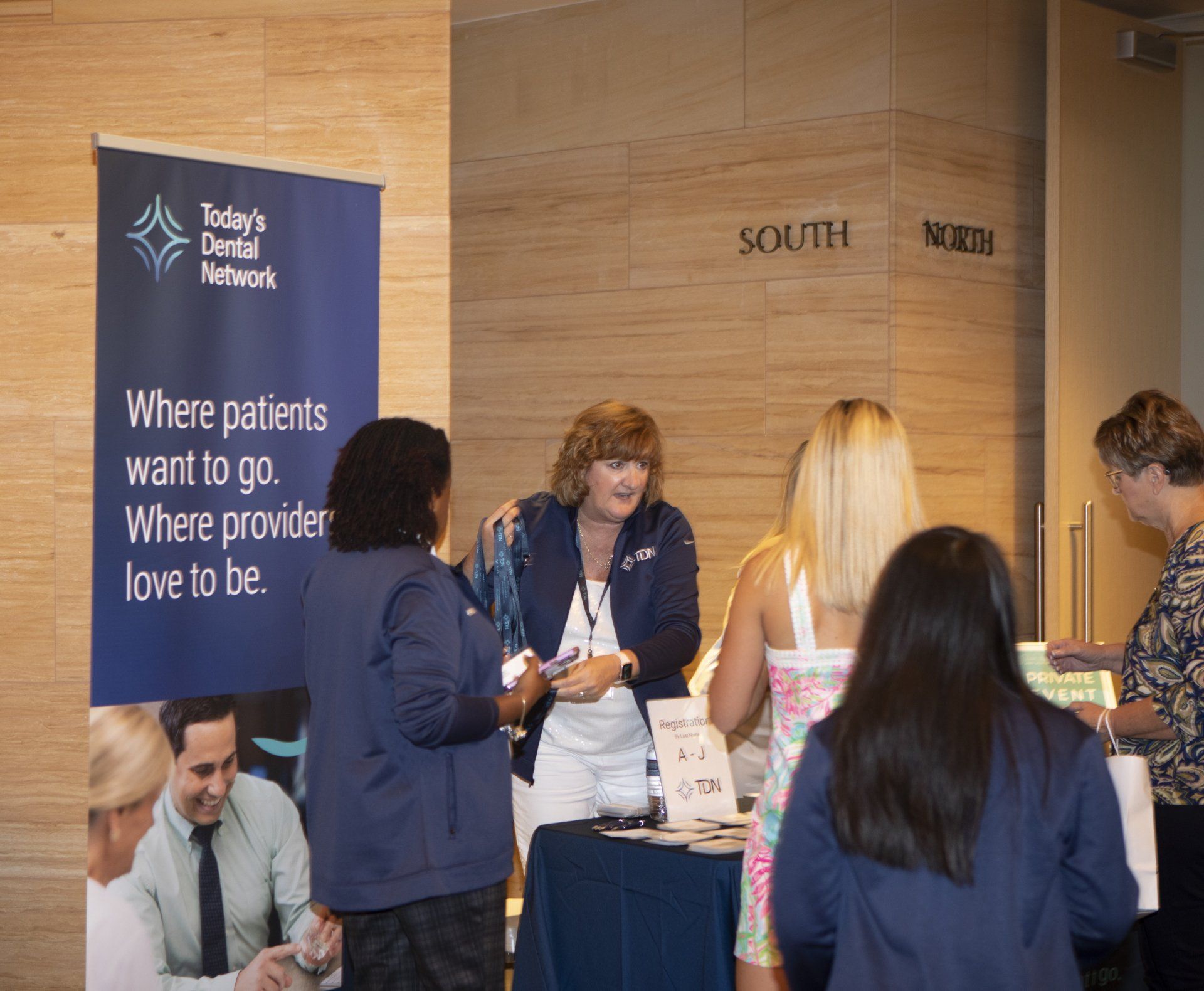 A group of people standing in front of a sign that says where patients want to go where provider love to be