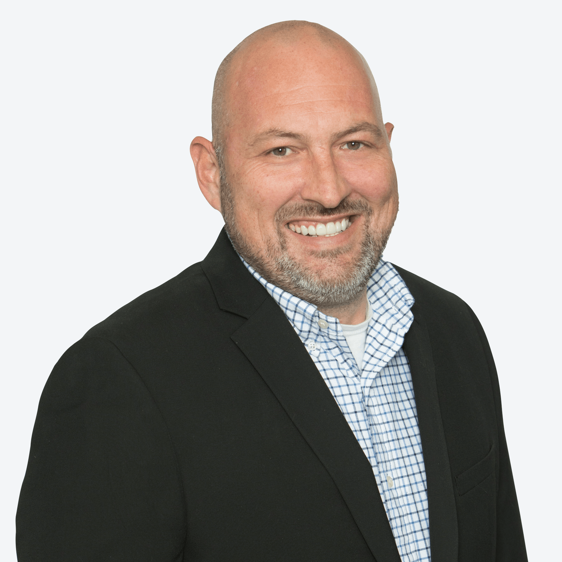 A man in a suit and plaid shirt is smiling for the camera.