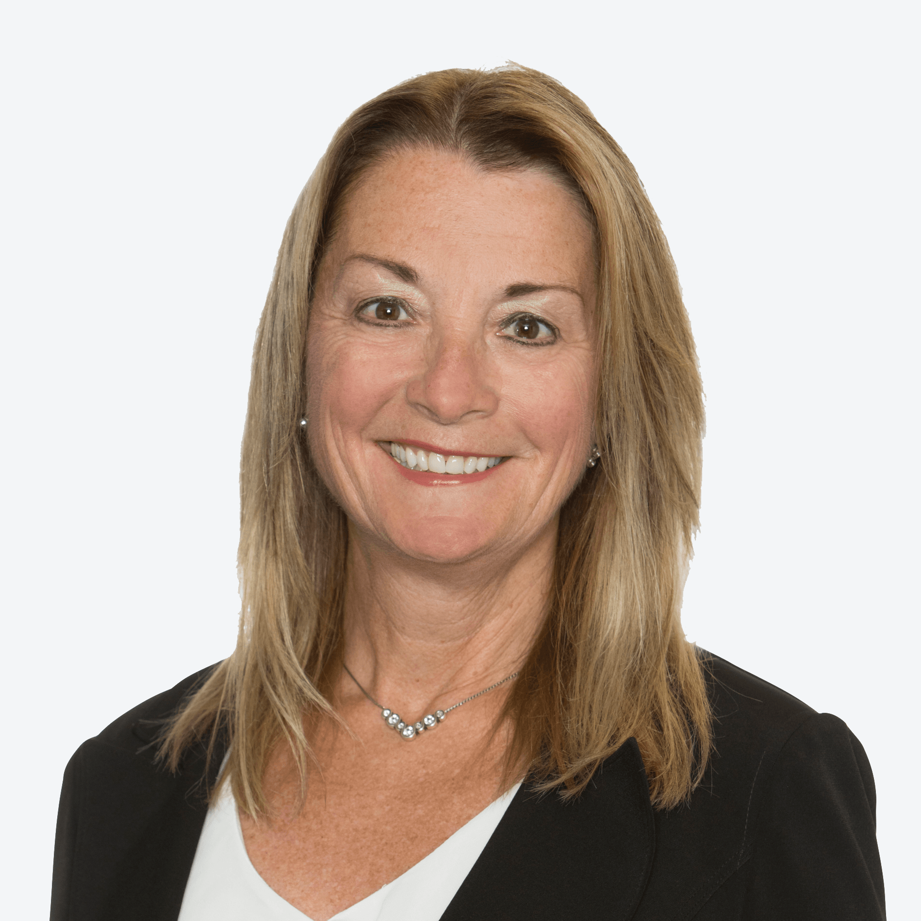 A woman wearing a black jacket and a white shirt is smiling.