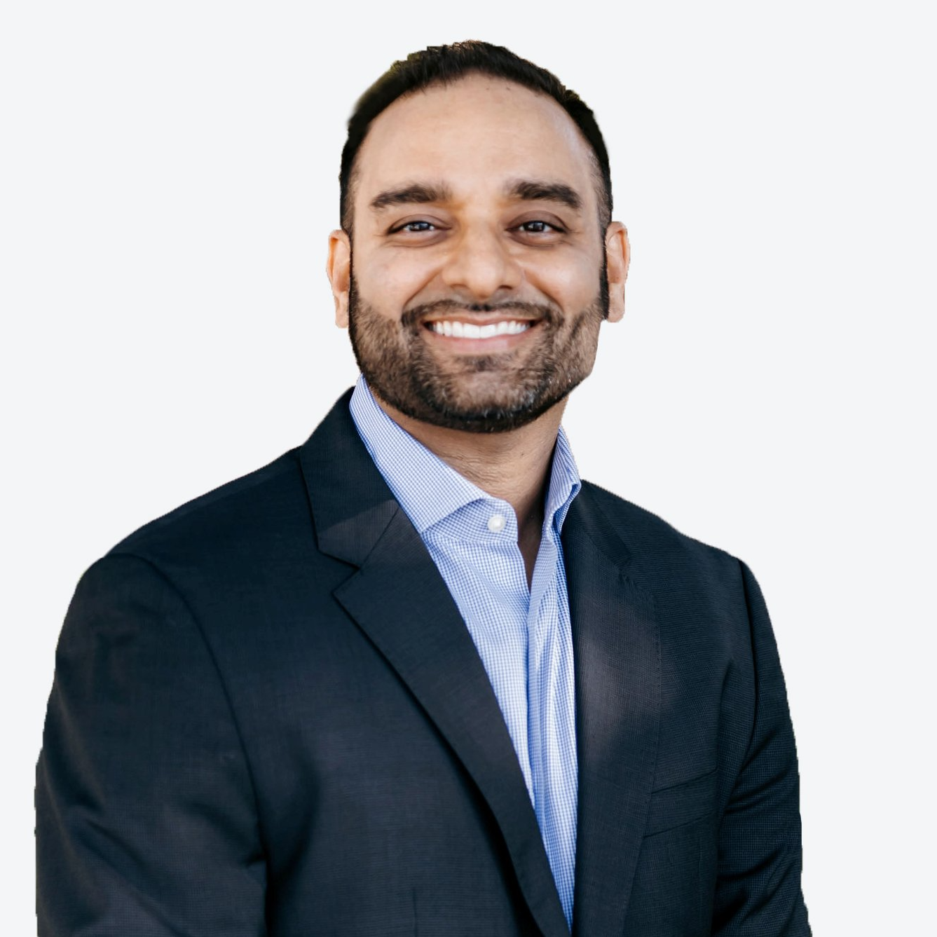 A man with a beard is wearing a suit and smiling
