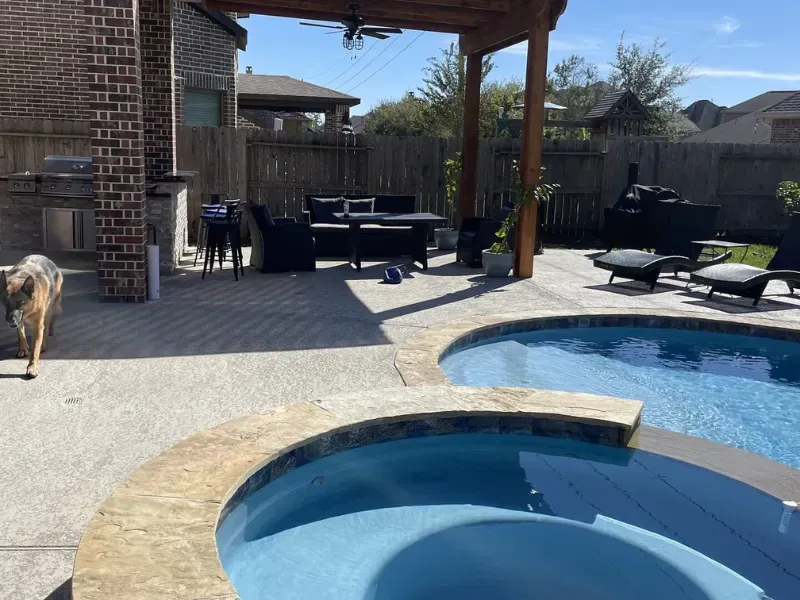 Backyard pool with a hot tub, patio furniture, and a covered seating area under a pergola.
