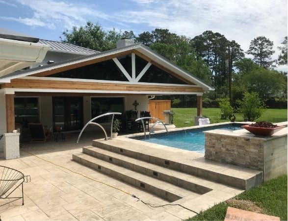 Backyard pool patio with steps, fountain jets, and a covered outdoor living area