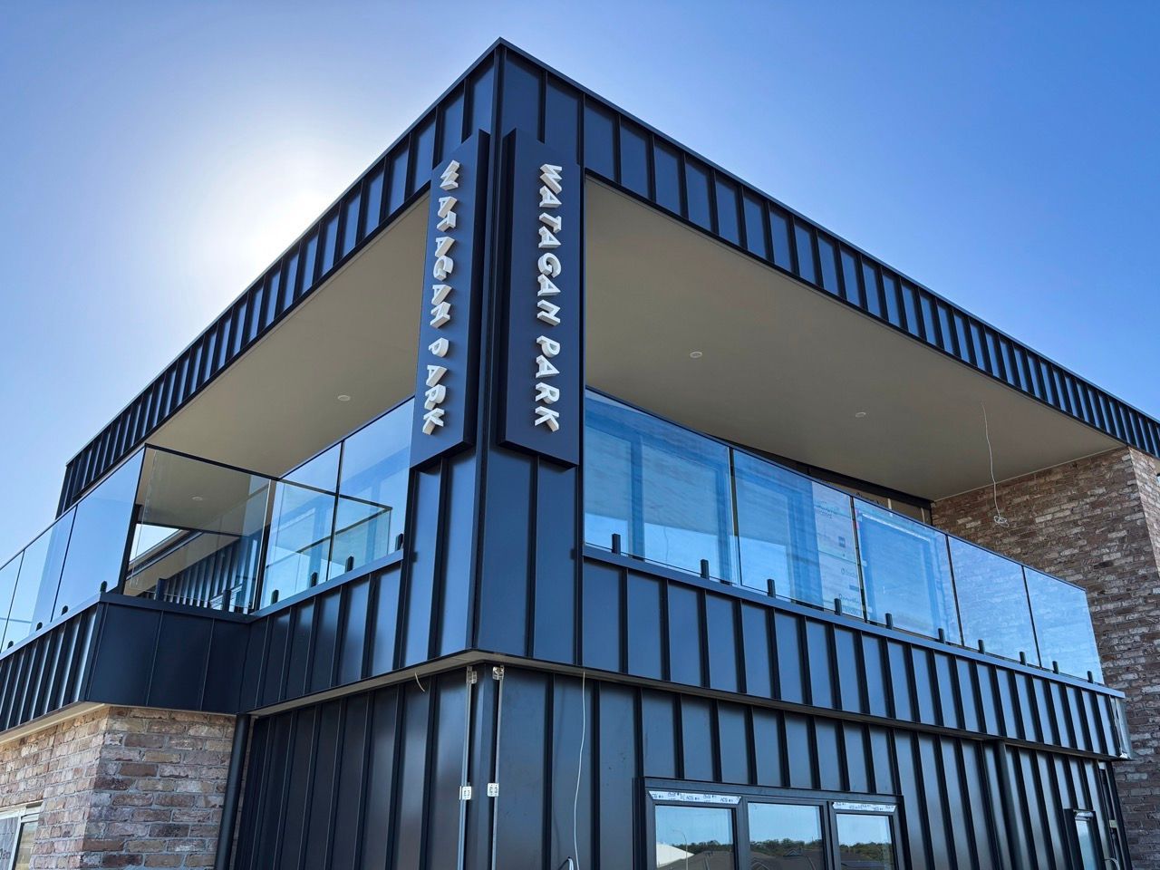 A blue building with a white sign on the side that says adropac.— Solis Signs in Toukley, NSW