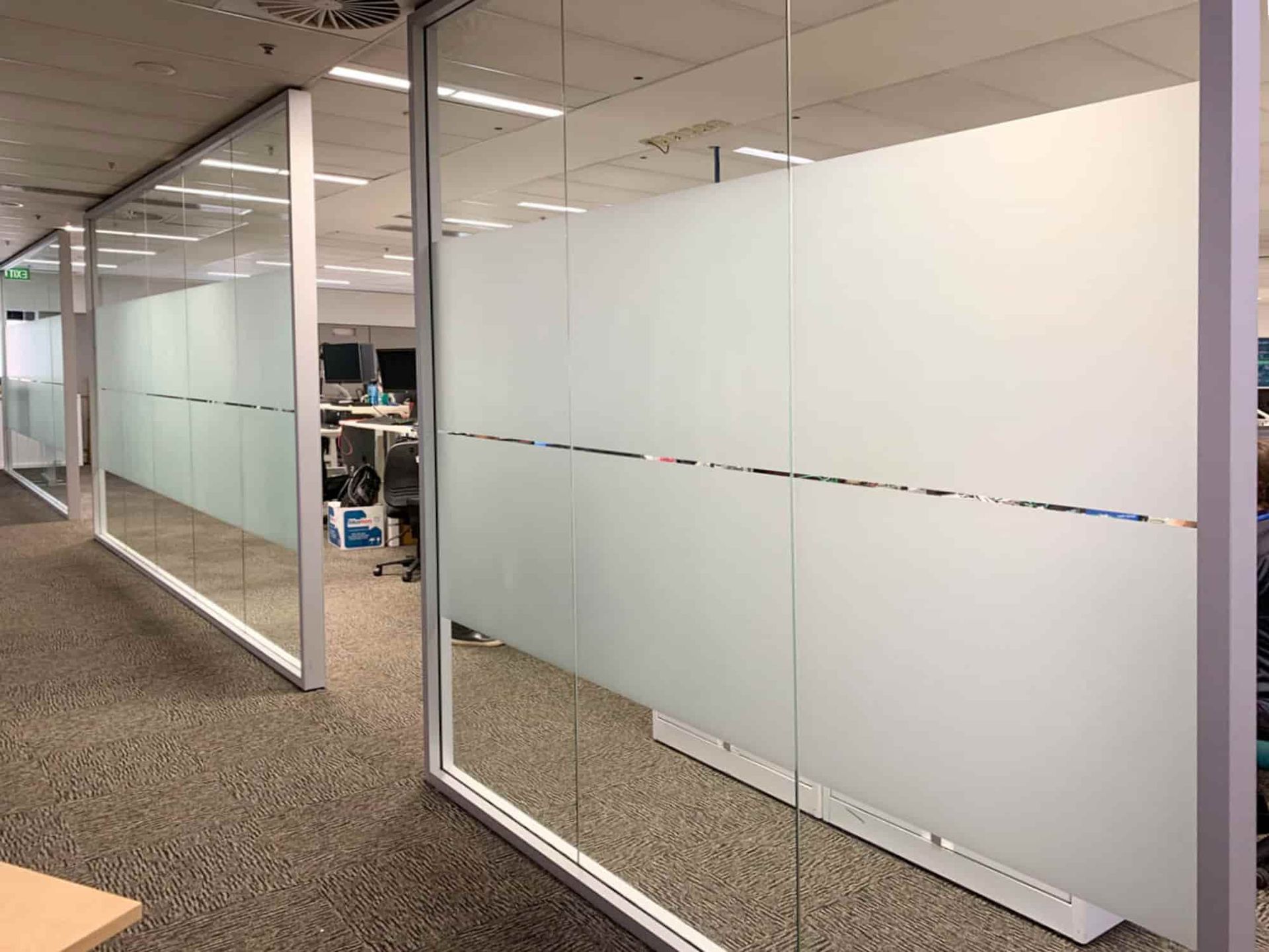 A room with a lot of glass walls and a carpeted floor. — Solis Signs in Toukley, NSW