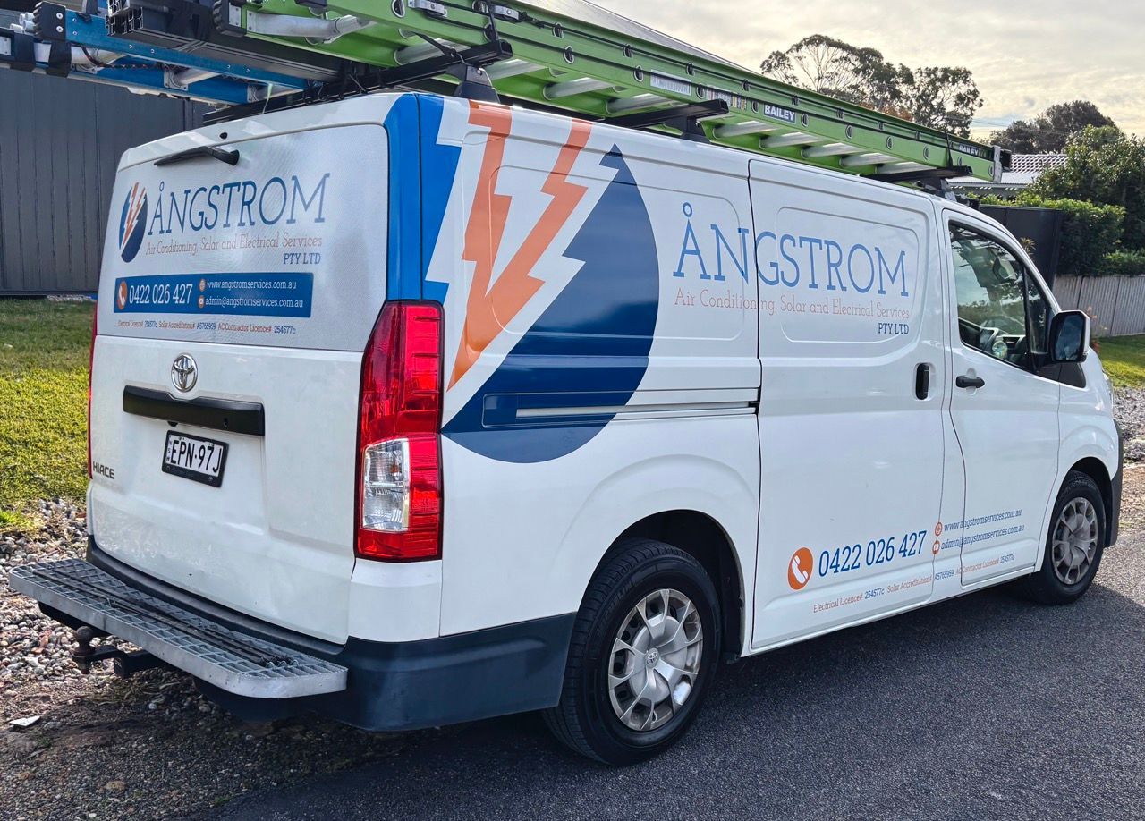 A White And Blue Van Is Parked In Front Of A House — Solis Signs in Toukley, NSW