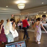 People dancing at a formal indoor event in a banquet hall