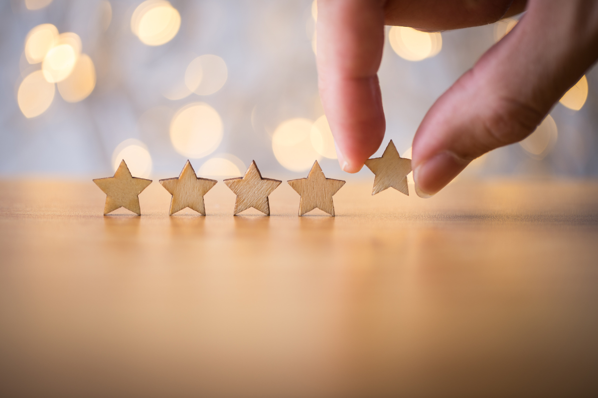 A hand placing a five-star rating, symbolizing the achievement of email marketing excellence with Visio SEO, highlighting the high quality and effectiveness of email campaigns that drive results for marketers.