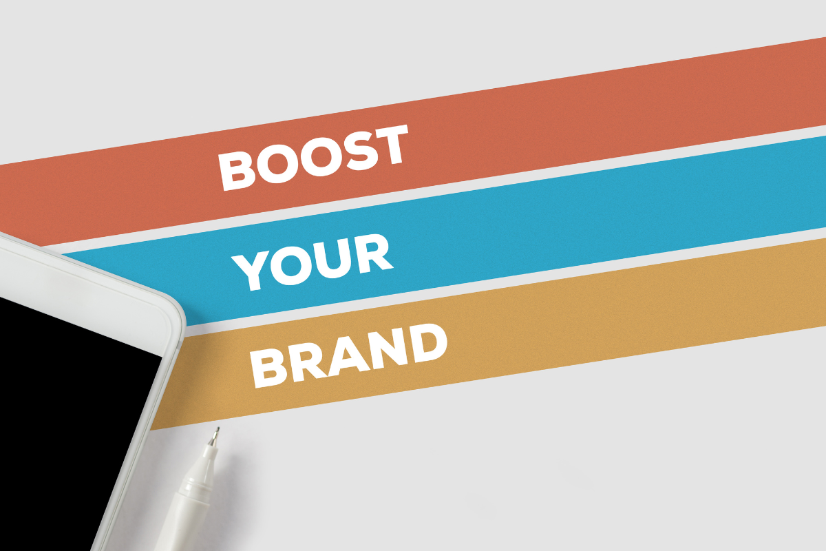 A phone and pen alongside the phrase 'Boost Your Brand,' highlighting how Visio SEO can boost your brand's reputation.