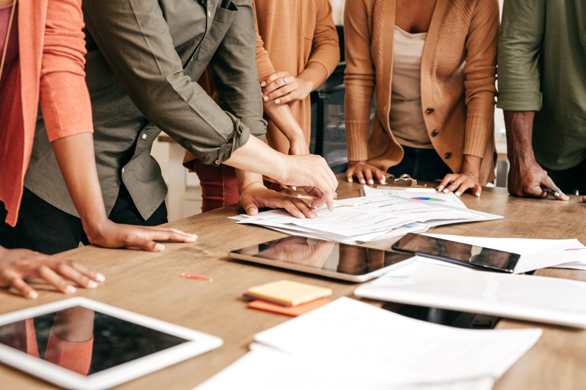 A group of people engaged in a focused discussion, planning strategies to drive results through enhanced social media engagement and audience interaction.