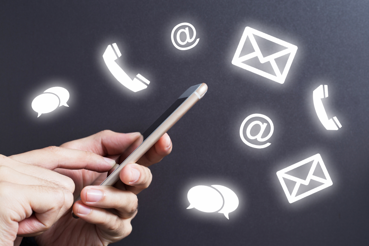Hands using a smartphone with icons for communication—email, phone, and chat—floating around, symbolizing connectivity.
