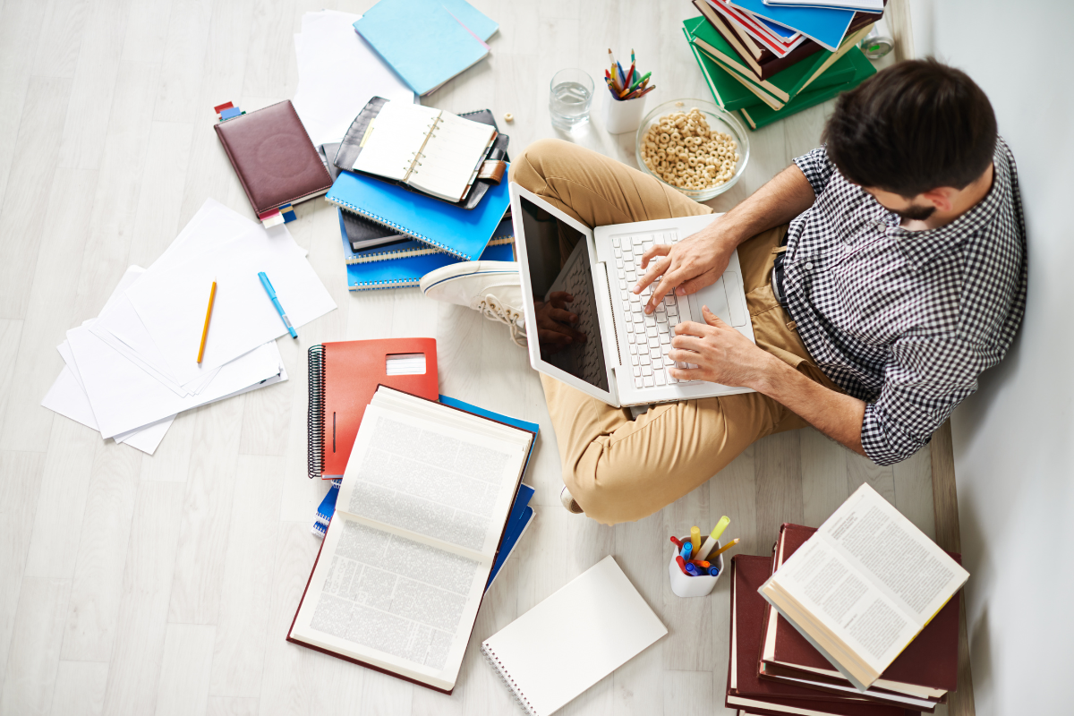 A man sitting on the floor with a laptop, illustrating tips and techniques for beginners in blog writing, related to how to write a blog post for beginners.