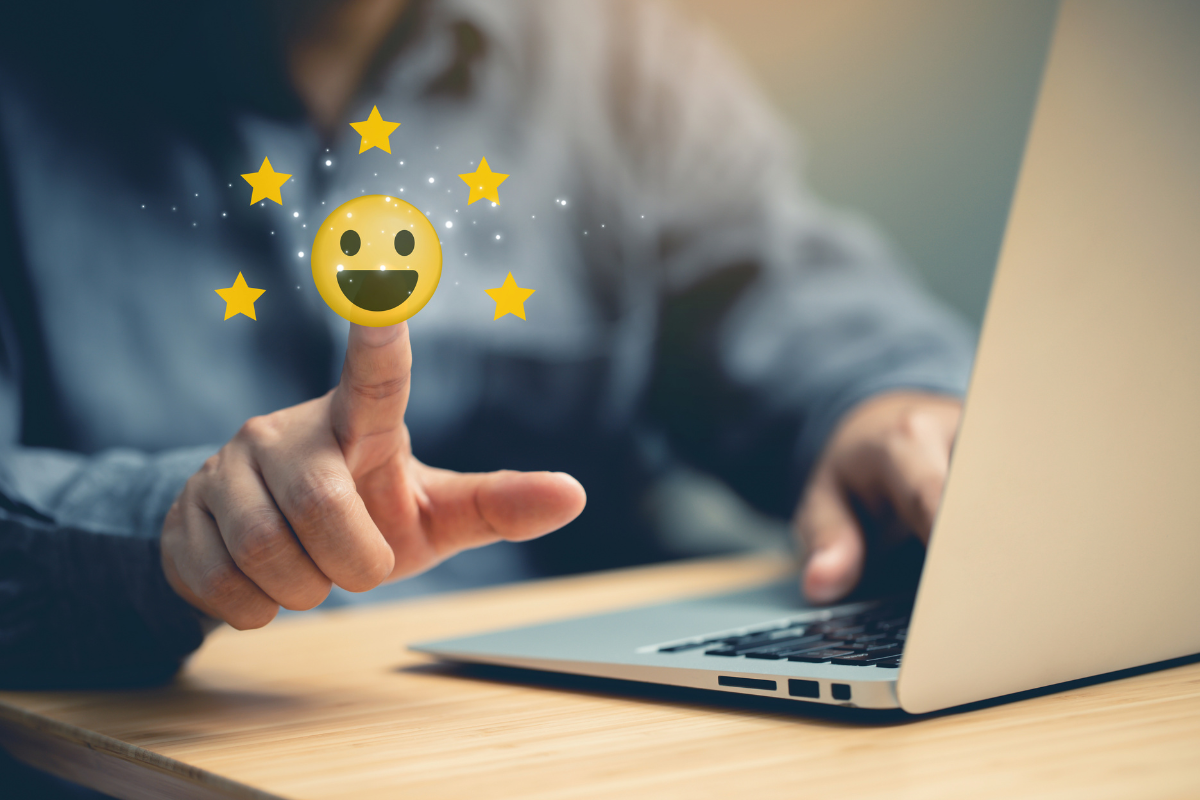 A person interacting with a glowing smiley face and stars, symbolizing positive reviews in small business reputation management.