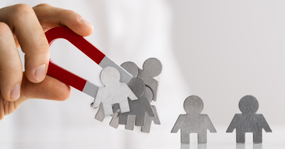 Hand holding magnet attracting metal figures, symbolizing a fast lead generation tool for capturing potential customers.
