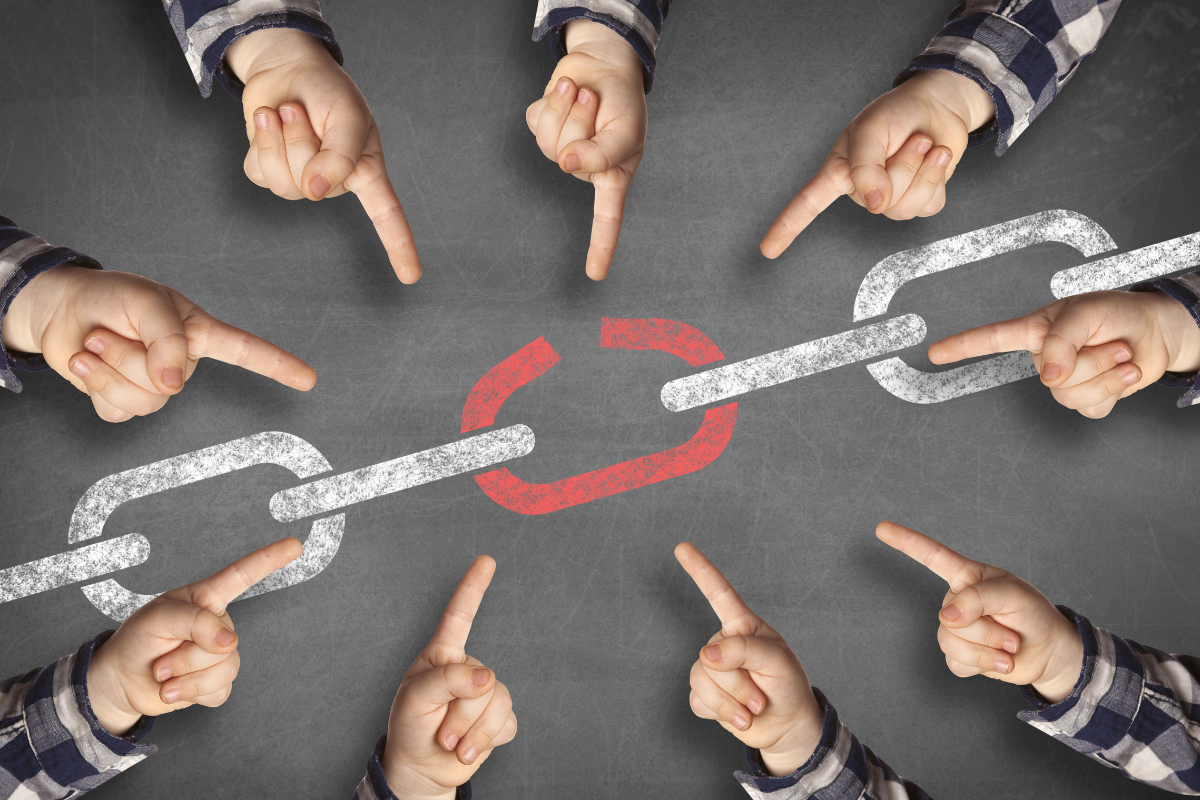 Multiple hands pointing at a broken chain link, symbolizing issues in internal linking and the need for connection repair.