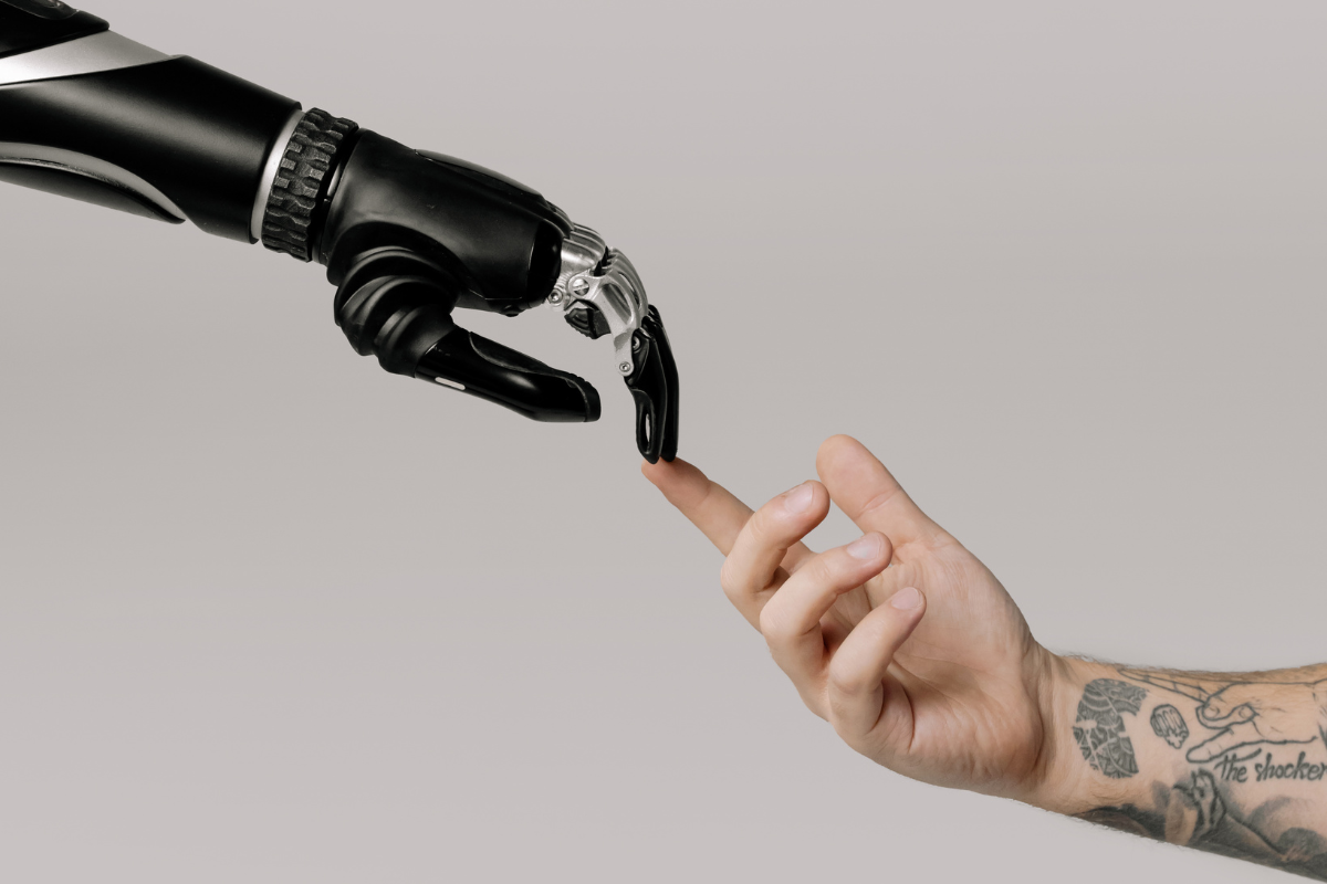 A robotic hand touching a human hand, symbolizing the collaboration of AI and humanity in shaping intuitive SEO trends.