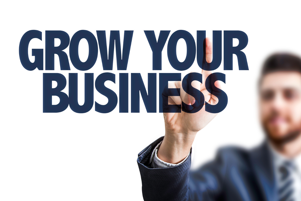 A man pointing to the words 'Grow Your Business,' illustrating how Visio SEO drives PPC success.