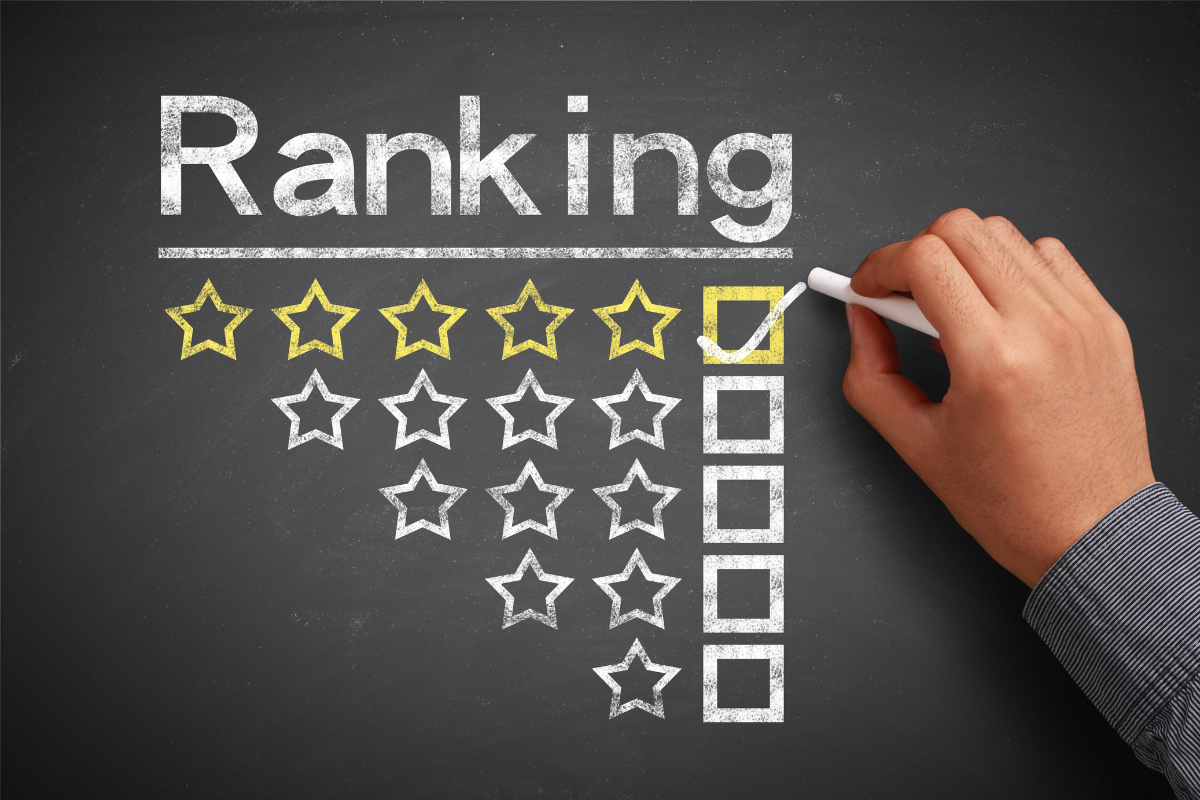 Hand drawing a five-star ranking on a chalkboard, highlighting quality and excellence with yellow stars and checkboxes.