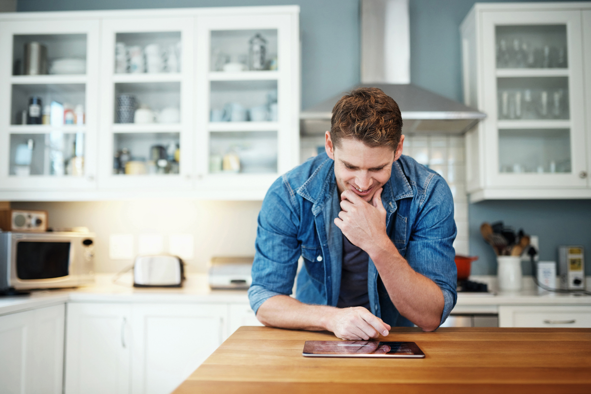 A man looking at a tablet, focusing on tasks related to online presence management and digital strategies.