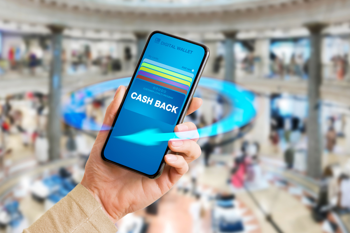 A hand holding a smartphone displaying a cashback reward program, representing customer loyalty and digital engagement.