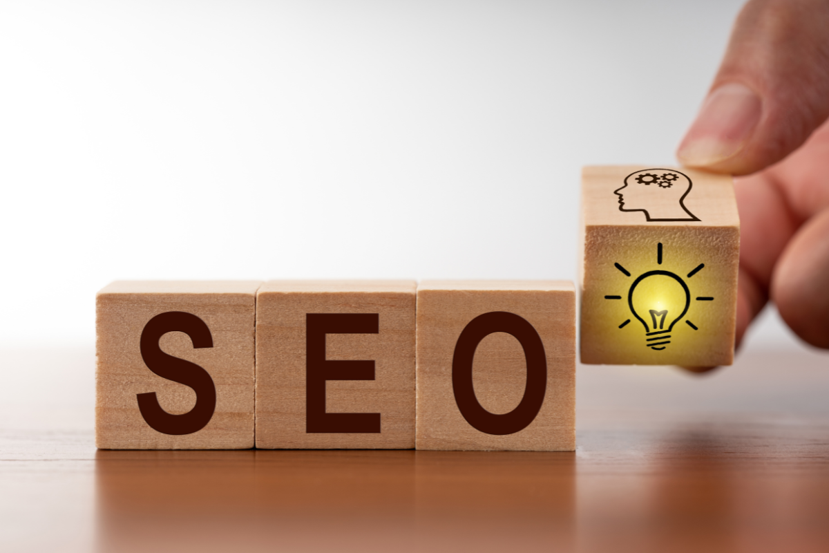 Wooden cubes featuring the word 'SEO' alongside cubes with bulb and brain illustrations, symbolizing innovation and strategic thinking, related to the future of local SEO trends to watch, highlighting the evolving techniques and insights shaping local search optimization.