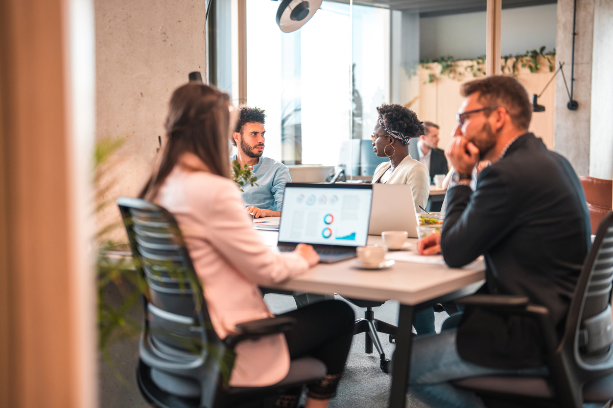 A group of people gathered around a table, collaborating as a Pay Per Click management agency to strategize and plan campaigns, highlighting the importance of PPC services in digital marketing.