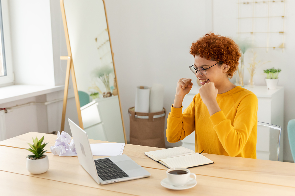 A woman joyfully celebrating in front of her laptop, highlighting the importance of link building and discovering rarely mentioned but highly effective strategies to boost online success.