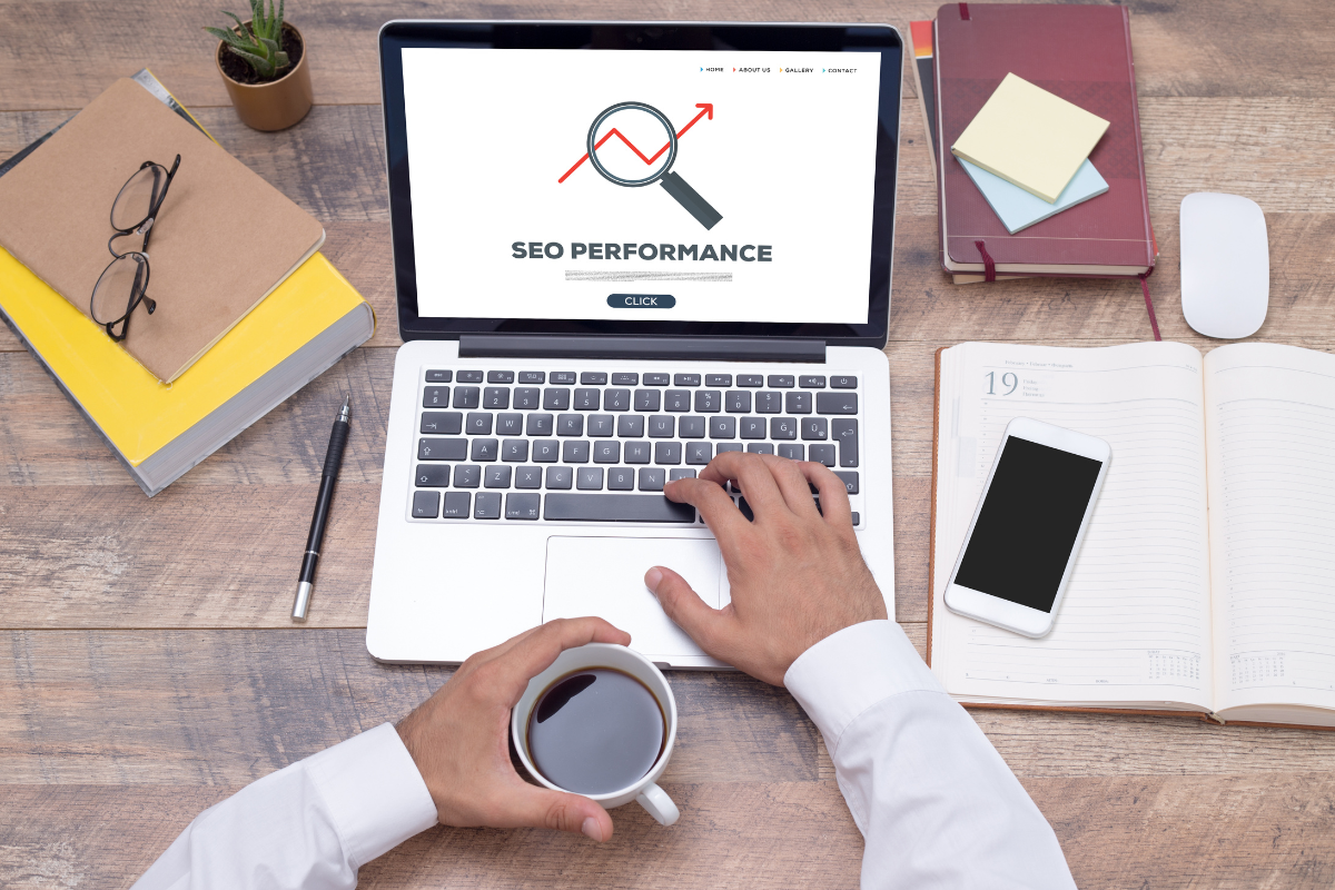 Person working on a laptop with 'SEO Performance' on screen, researching what are SEO best practices and ranking factors.