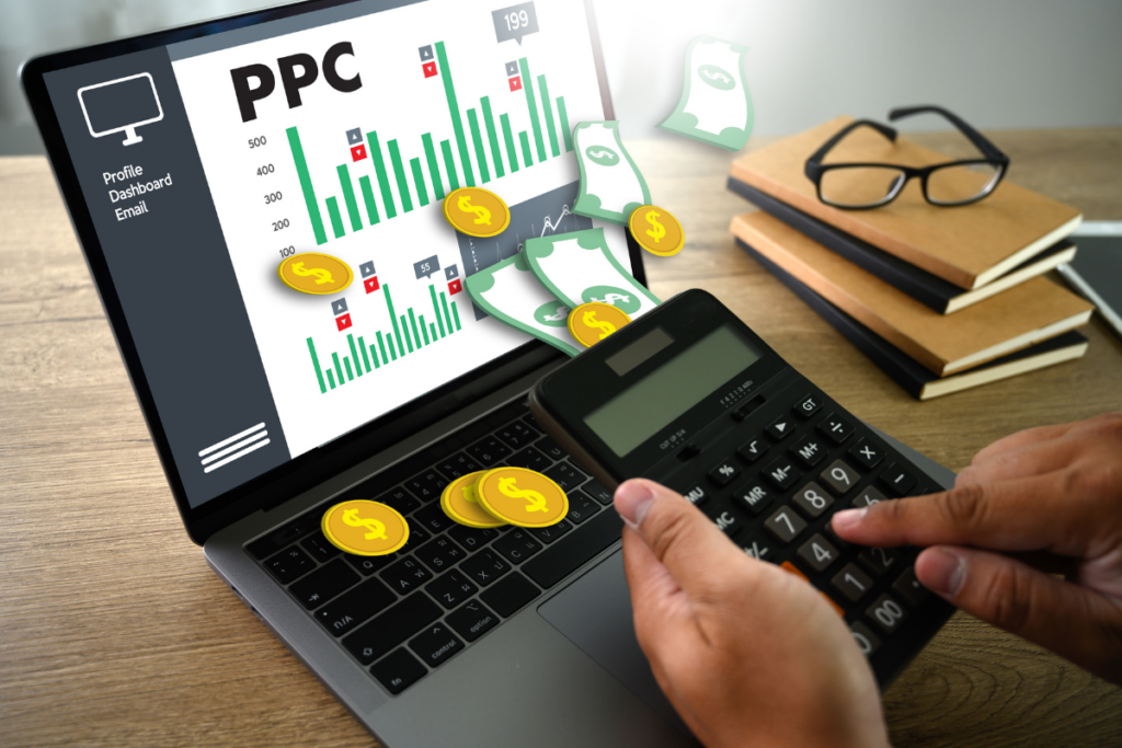 A person using a calculator with a laptop displaying PPC metrics, representing key aspects of Pay Per Click management.