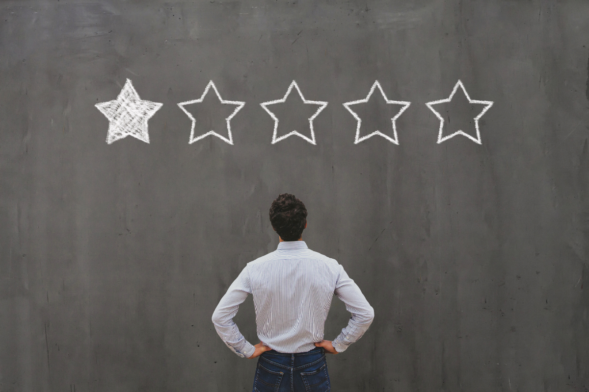 A man examining a five-star rating, representing the concept of reputation management and its importance in assessing and enhancing brand perception.
