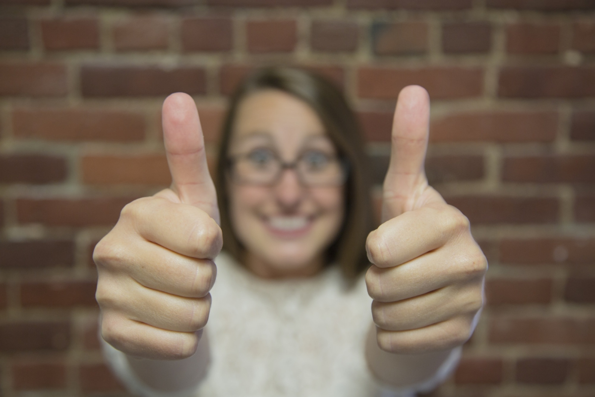 A woman giving a thumbs up, representing the qualities of engaging and well-crafted blog writing, highlighting what makes a good blog.