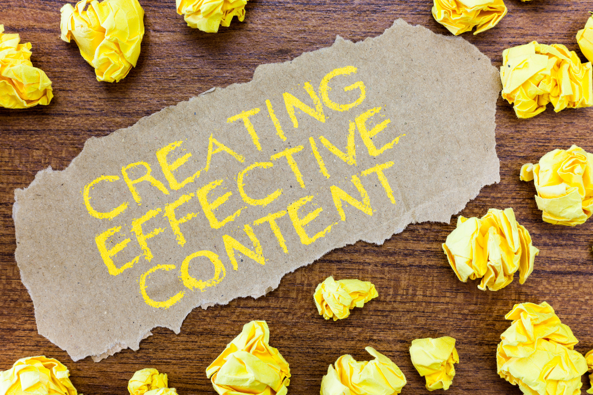 A piece of paper with yellow writing that says 'Creating Effective Content,' surrounded by crumpled papers, symbolizing the process of writing effective blog posts.