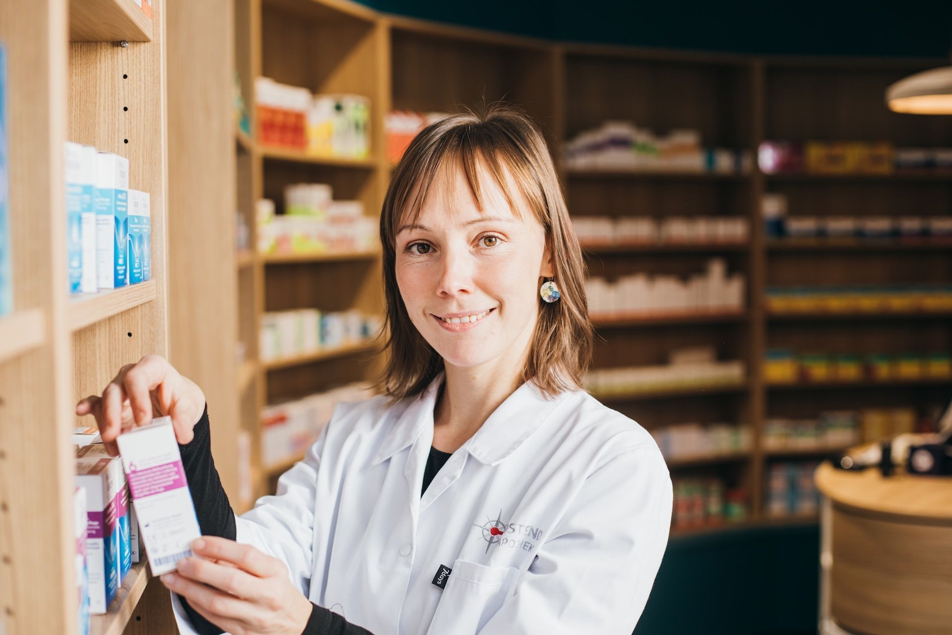 Michaela Bryla, Apothekerin Ostend Apotheke Dresden Neustadt holt ein Produkt aus dem Regal