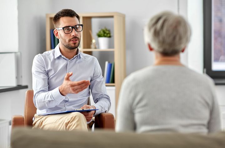 psychologist talking to senior woman patient at psychotherapy session