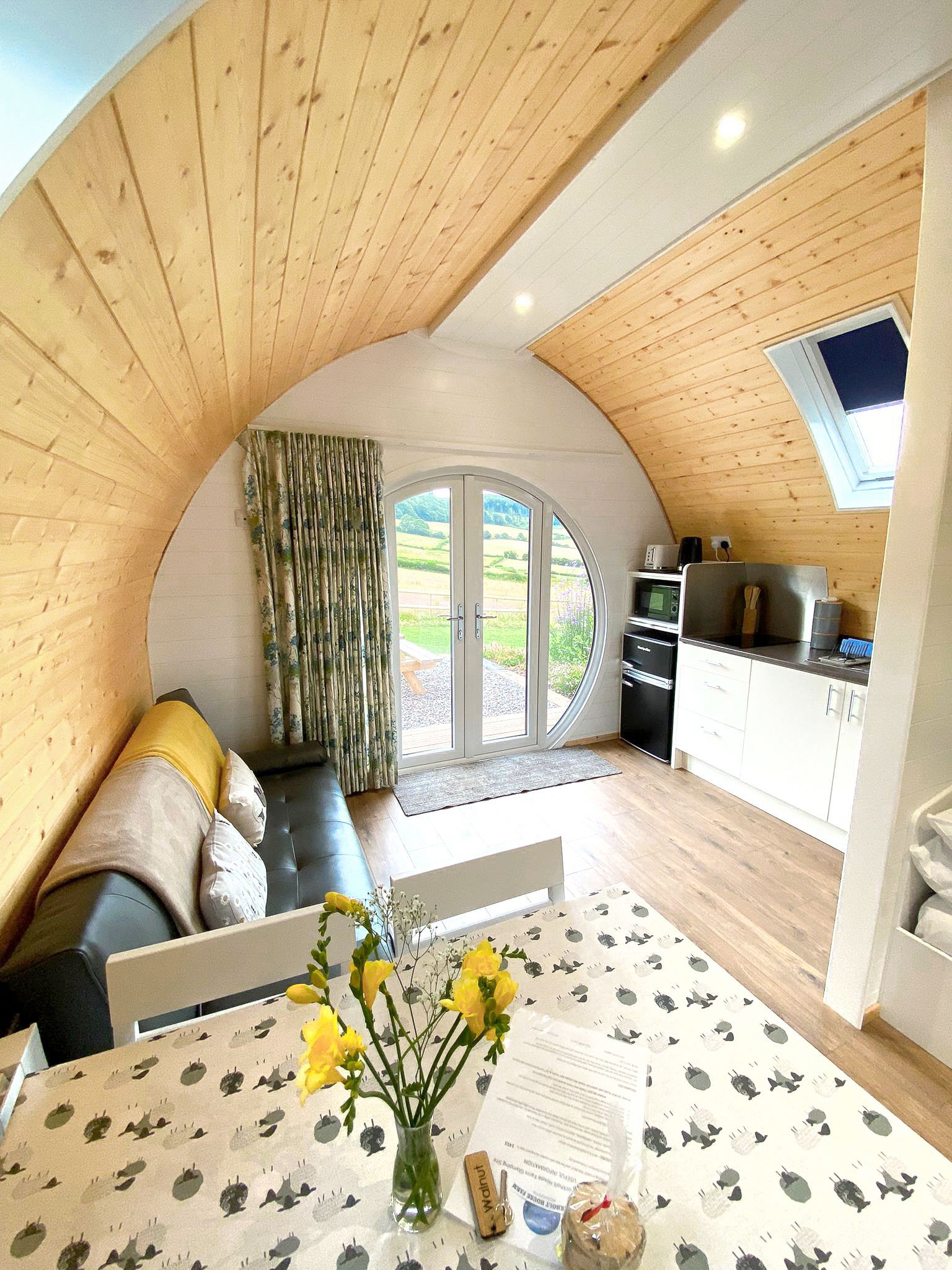 Luxury glamping pod with kitchen and seating area