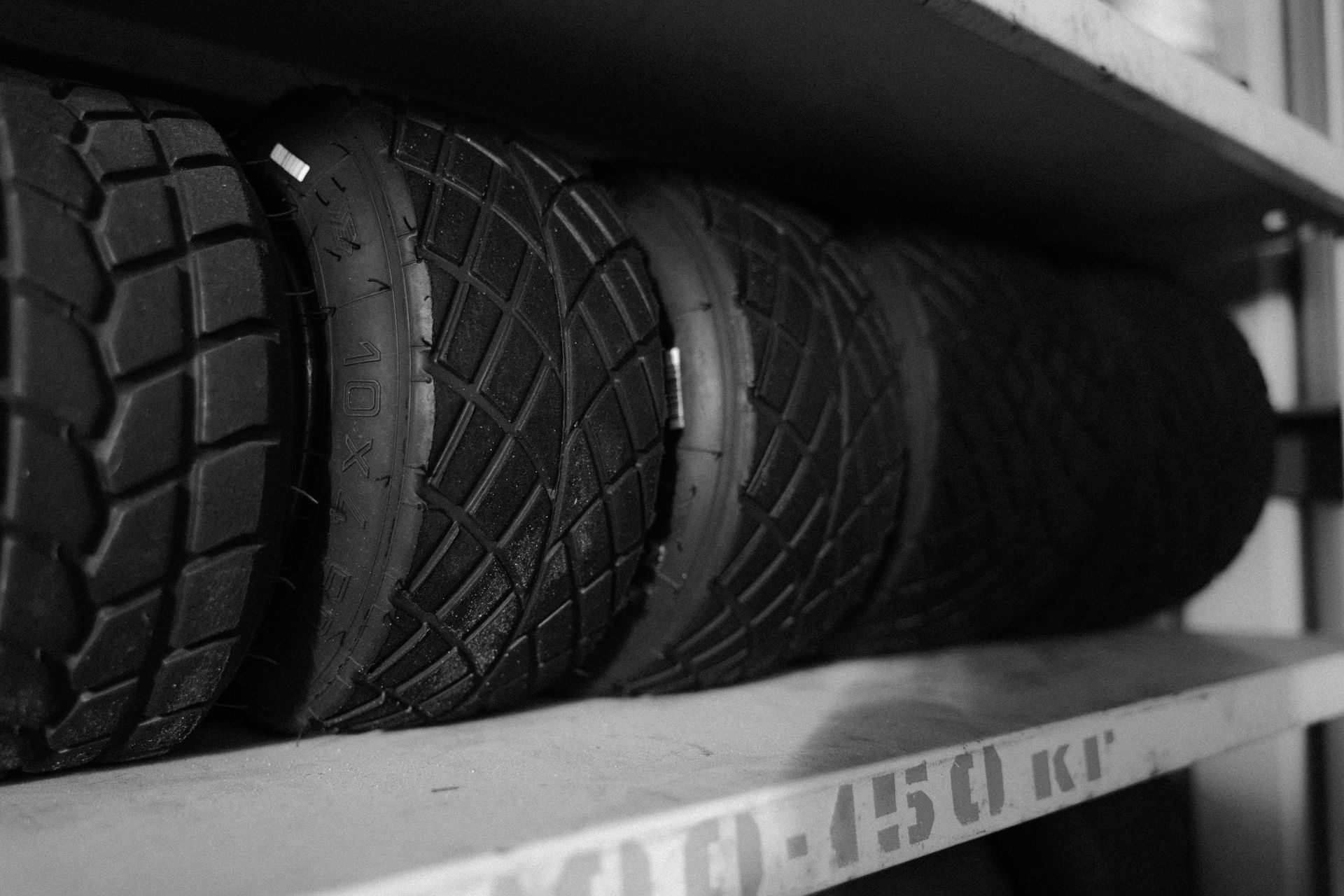 A black and white photo of a stack of tires on a shelf.