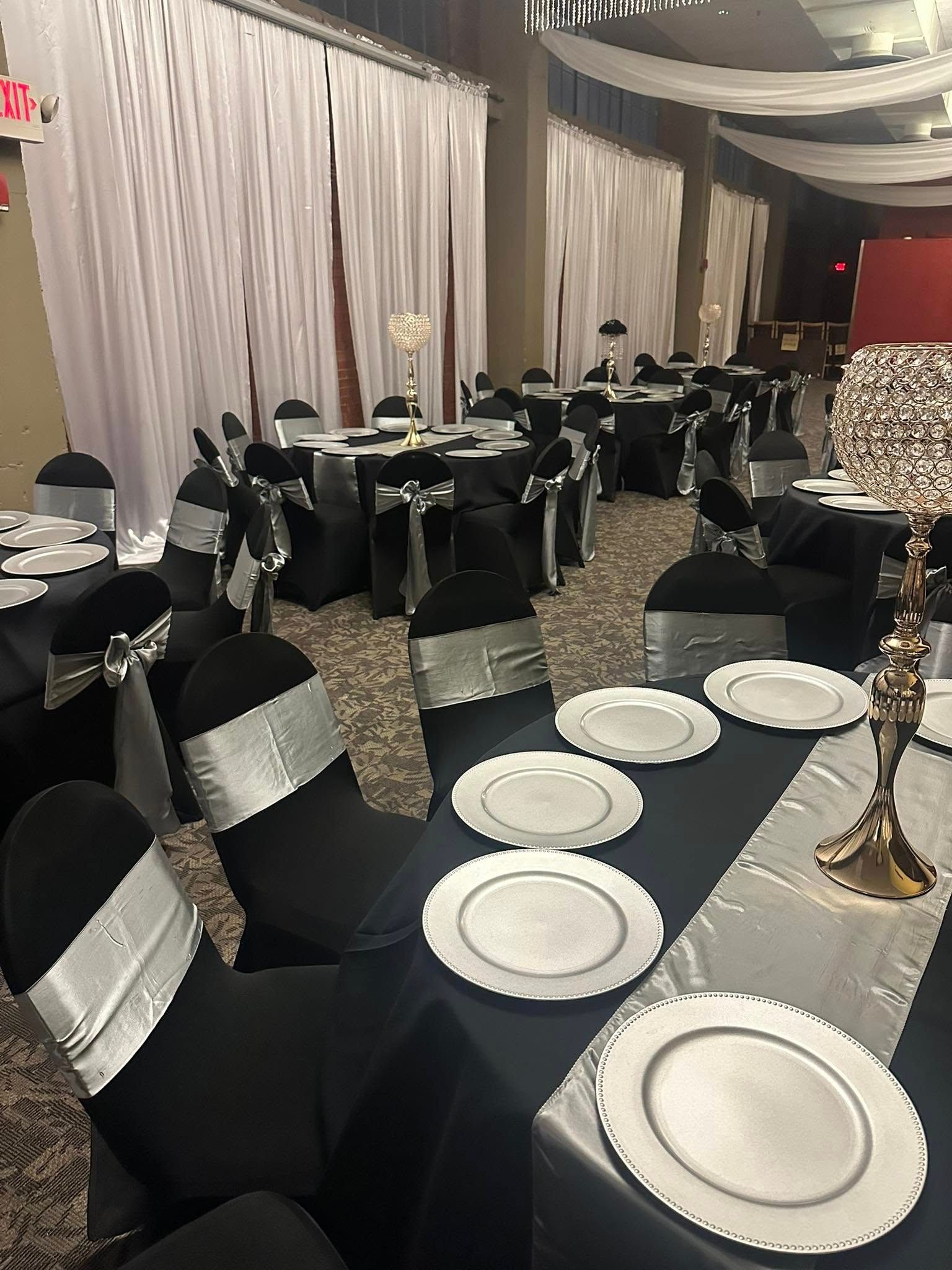 A large room with tables and chairs set up for a wedding reception.