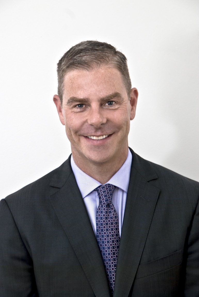 A man in a suit and tie is smiling for the camera.