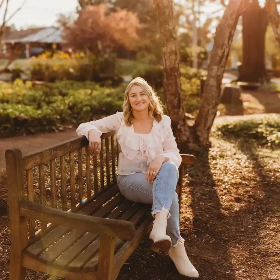 Therapist sitting on a bench at a park.