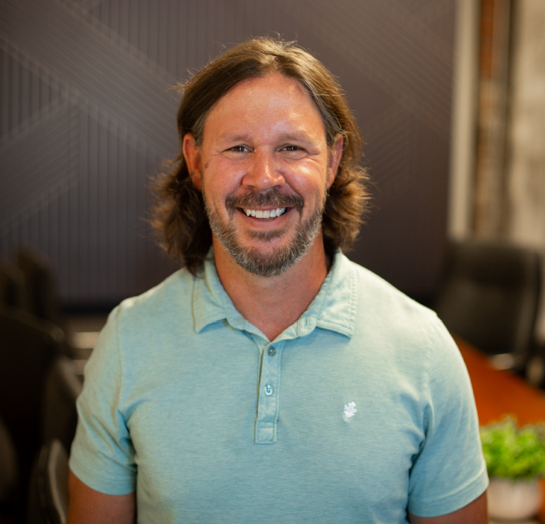 A man in a suit and tie is smiling for the camera