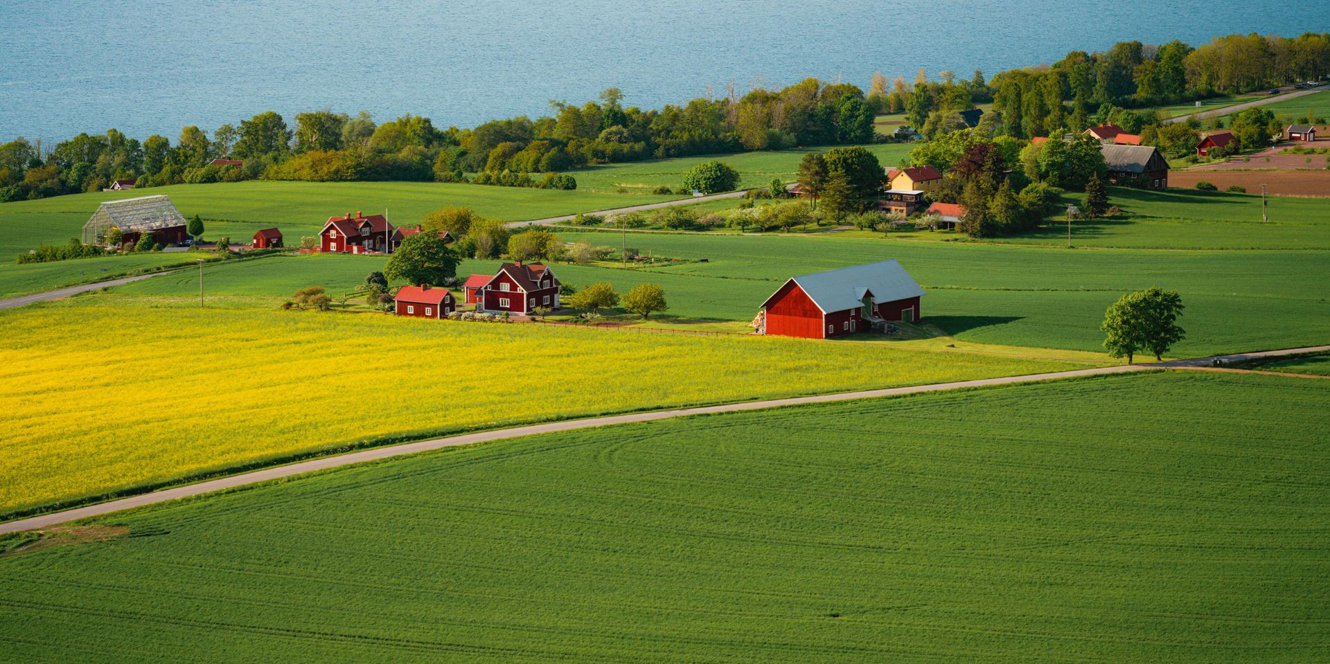 An aerial view of a farm with a red barn in the middle of a field.
