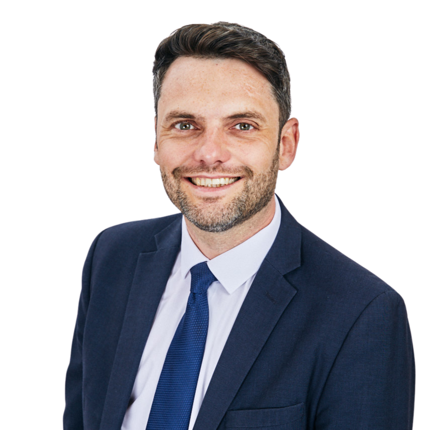 Smiling man in a navy suit and blue tie against a white background