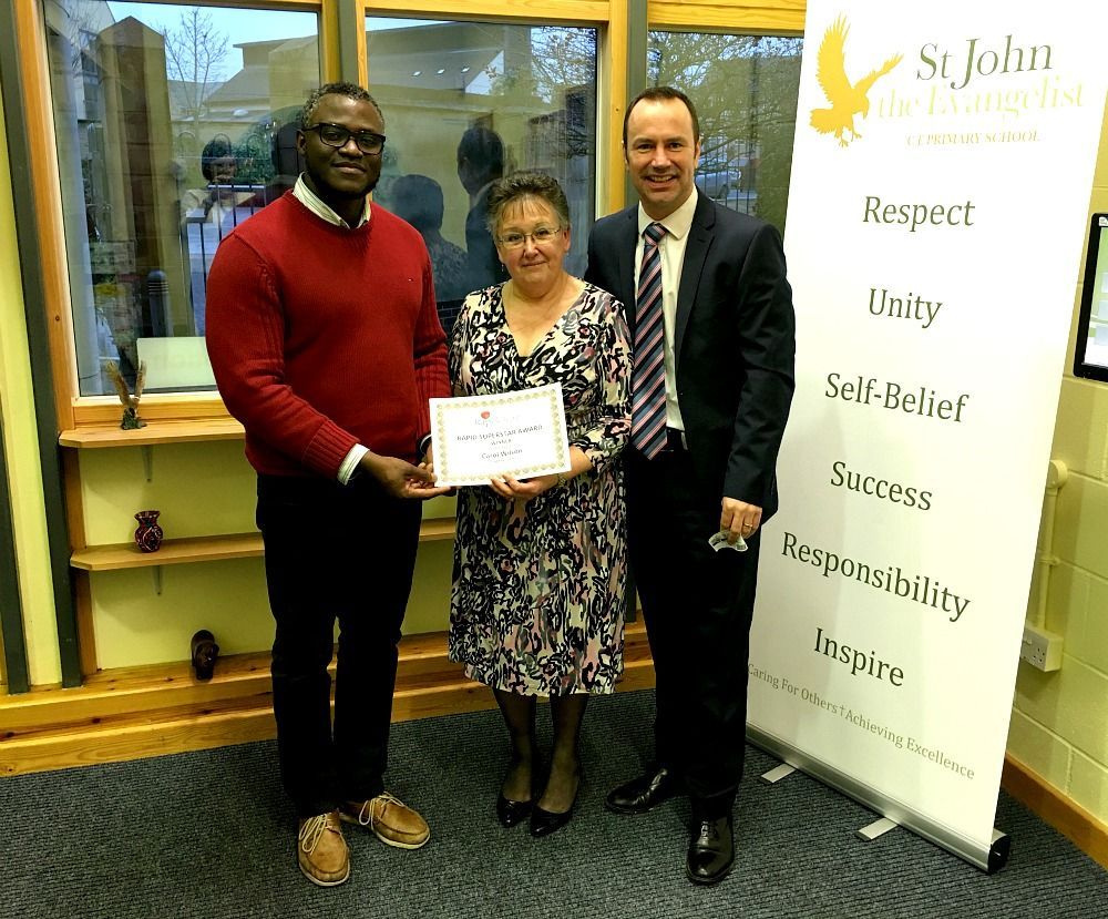 Three people standing in front of a sign that says respect unity self belief success responsibility inspire