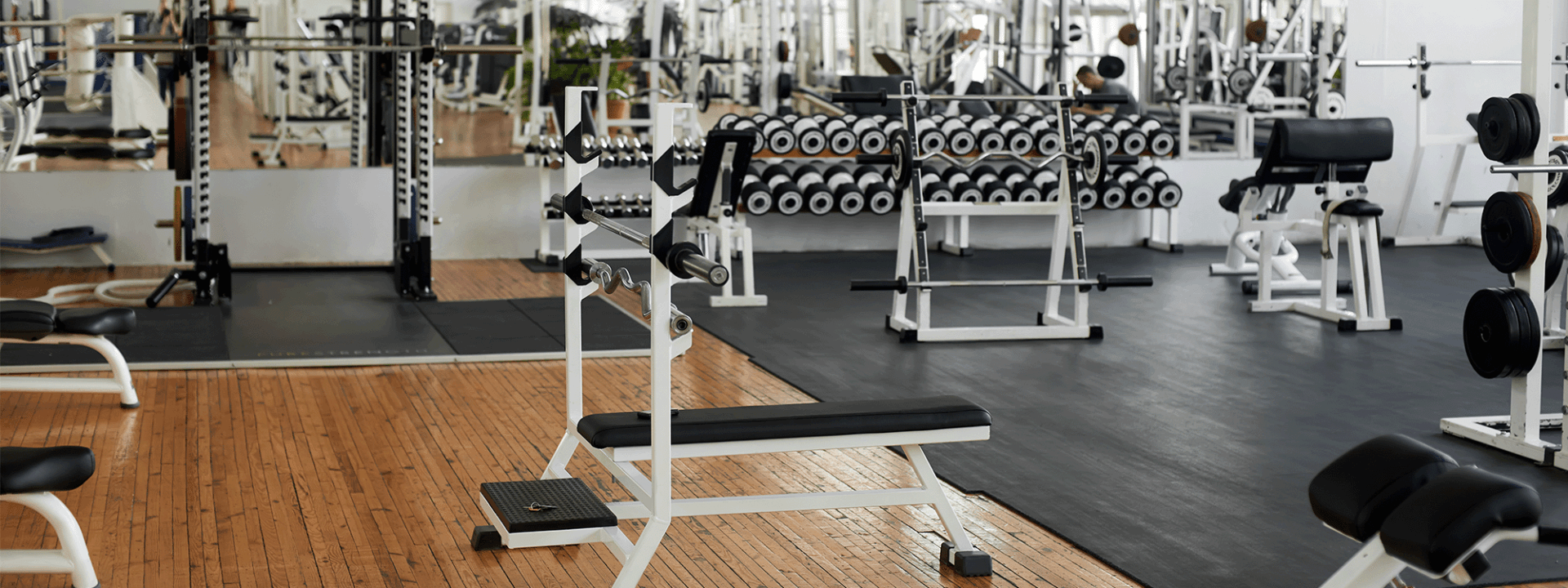 A gym filled with lots of dumbbells and benches.