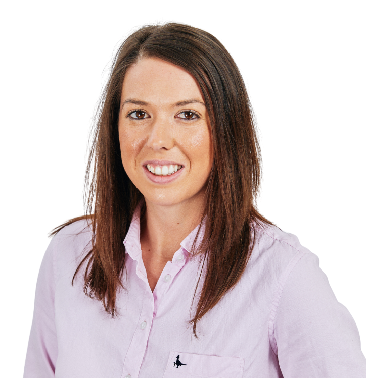A woman in a pink shirt is smiling for the camera.